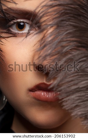 Portriat of woman with a feather at her eye. Fashion art style make up. Fashion goth concept. Feather. Beauty skin