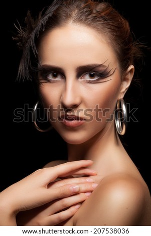 Woman with feather in head on black background. Art fashion goth style. Beauty. Perffect skin