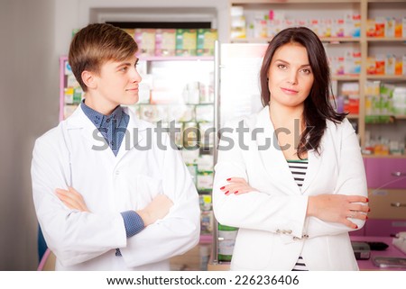Druggist and client in front of pharmacy table. Drugs and pills in the background. Medical background