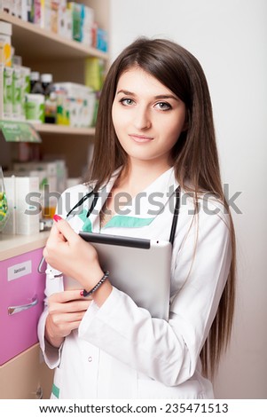 Young pharmacist woman with digital tablet in hands. Smiling at camera. Health care business. Business style