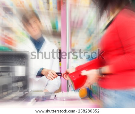 Customer paying with credit card in a pharmacy. Happy customer and pharmacist. Pharmacy, doctor. Healthcare and medical care. Business