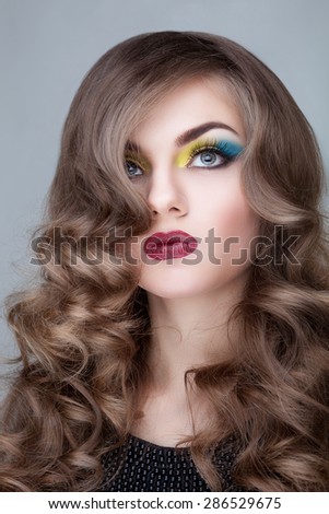 Fashion make up on girl over grey background. Beauty and fashion photoshooting. Attractive make up on sensual girl