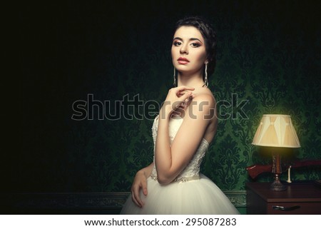 Beautiful bride in luxury vintage interior with green retro pattern. Happy bride. Beautiful young woman getting married. Wedding photo. Studio shooting