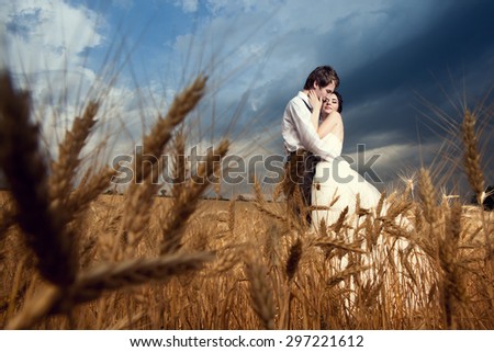 In loved bride and groom in wheat field over blue sky. Just married. Young happy couple getting married. Love and tenderness