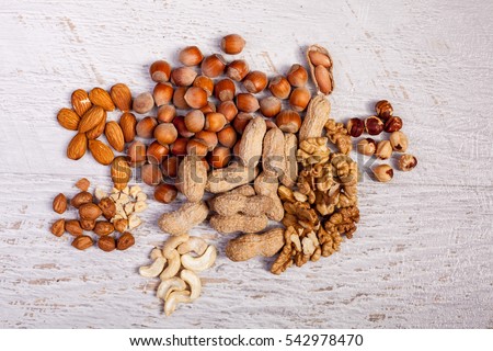 Different type of nuts of white wooden background. Healthy food