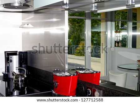 Home interior kitchen painted in white, brightly lit, with a good view of black granite counter top