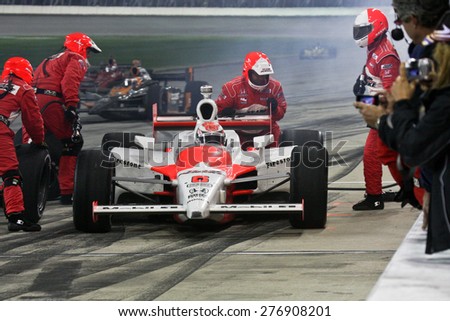 Joliet Illinois, USA - August 29, 2009: IndyCar Racing League. Pit stop during the race. Ryan Brisco driver for Penske racing. Team changes tires and fuels the car. Chicagoland speedway. Night Racing