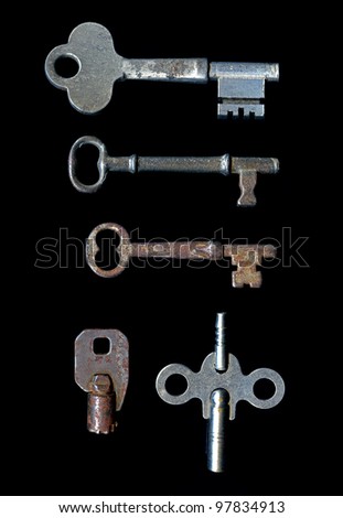 five old keys some rusty some silver on a plain black background isolated