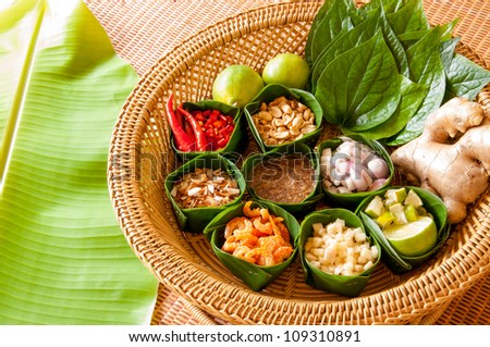 Miang Kham is a tasty snack often sold as Thailand street food. It involves wrapping little tidbits of several items in a leaf, along with a sweet-and-salty sauce.