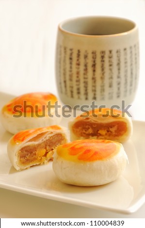 Egg yolk cakes with a cup of tea, traditional asian style pastry.
