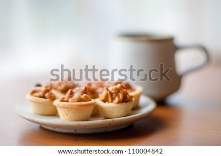 Cashew tart on serving plate. [Focus with a cashew tart]