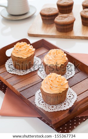 Cupcakes dessert with butter-cream swirl topping and sugar pearls decoration for coffee and tea.