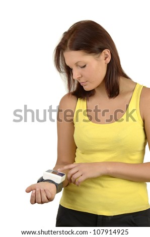 Young sporty woman in a yellow tank top controls blood sugar levels on the meter, portrait format, isolated on white background