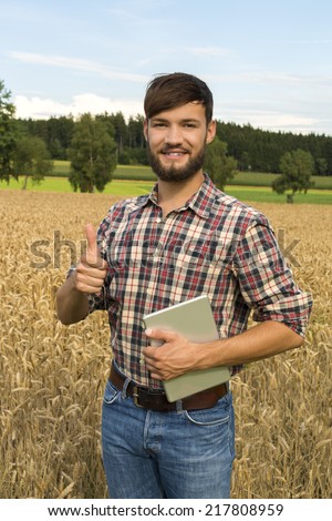 Young farmer at his corn field, thumb up , Outdoor Shot