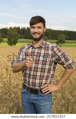 Young farmer at his corn field, thumb up , Outdoor Shot