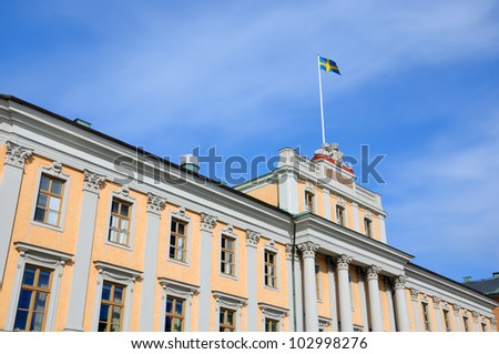 A building at Gustav Adolf\'s square and the swedish flag in Stockholm