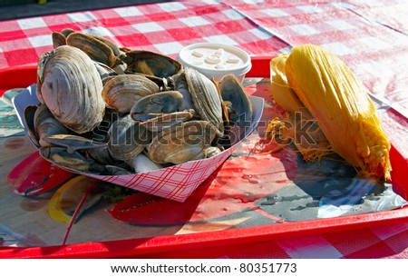 A plate of clams served with the corn-on-the-cob.