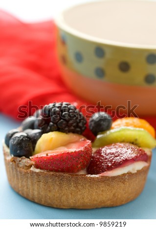 A dessert fruit tart of cream, berries, and citrus fruit.