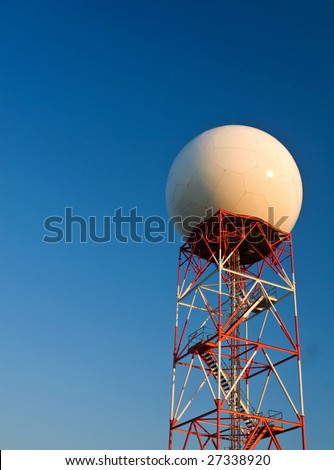 A doppler weather radar at sunset against a blue sky background.  Copy space on top.