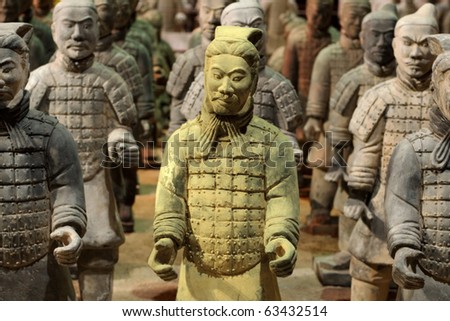 Chinese Qin warrior statues with one gold tinted in a crowd of grey.
