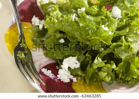 Organic Green Leaf salad and a trio of sliced beets, topped with dressing and goat cheese.