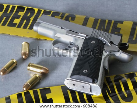 A .45 caliber pistol with bullets, with crime scene tape.
