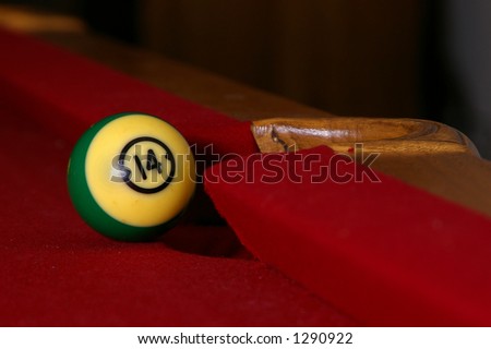 Pool ball nearly makes it into the pocket.