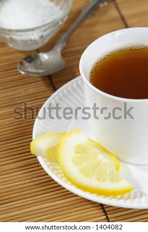 Cup of hot tea with lemon and sugar.