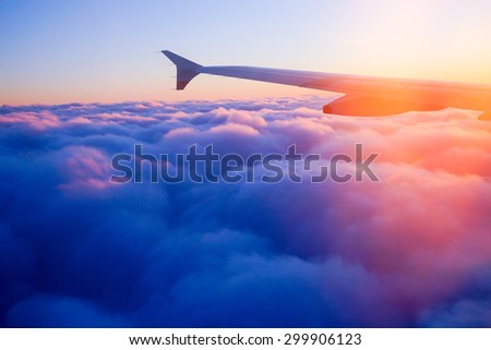Airplane Wing in Flight from window, sunset sky