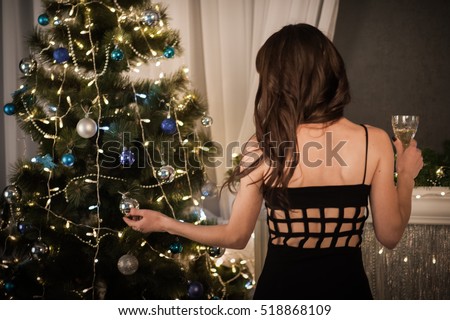glasses with champagne in the hands of a beautiful woman on New Year\'s or Christmas