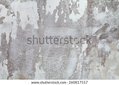 Old white concrete wall. Paint peeling off the walls.