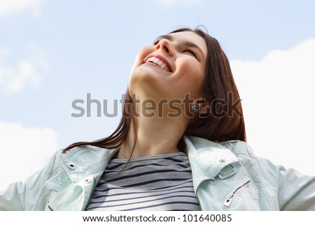 Happy smiling young attractive woman over clean blue sky
