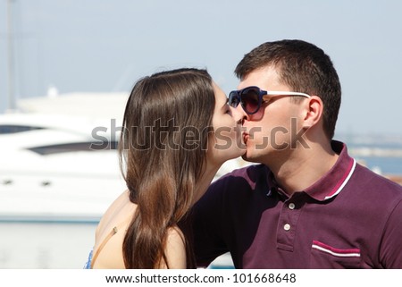 young beautiful caucasian couple hugs and kiss in yacht club