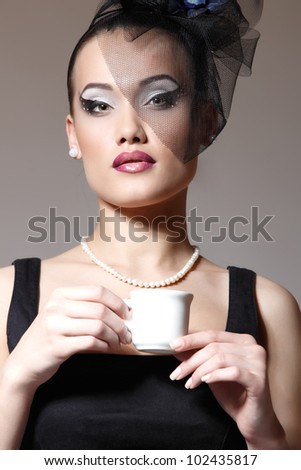 Beautiful woman in veil retro glamour beauty portrait with cup of tea or coffee