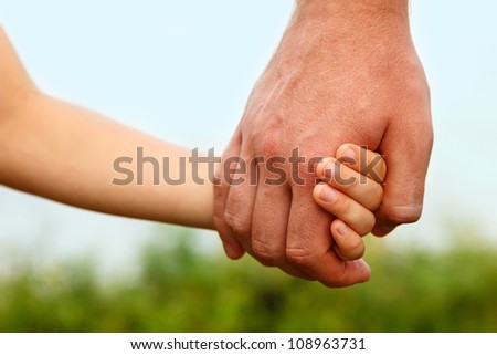 father\'s hand lead his child son in summer forest nature outdoor, trust family concept