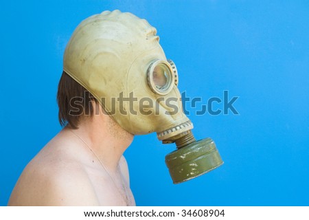 funny portrait of man with gas mask against blue background