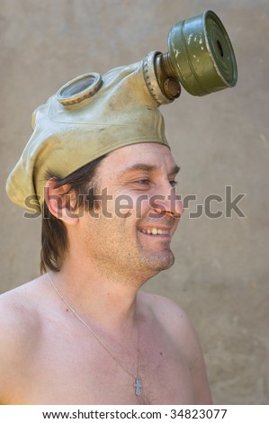 laughing man with gas mask against concrete wall
