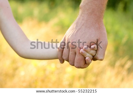 father lead by the hand son outdoor