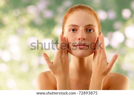 summer woman young beautiful no make-up touching face with her hands over nature background