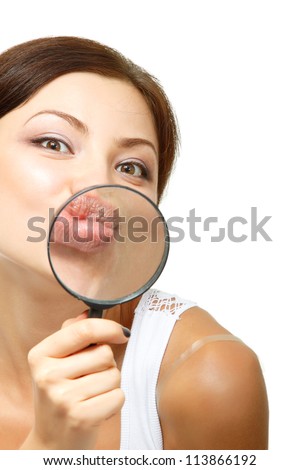 attractive young woman give kiss through a magnifying glass over white background