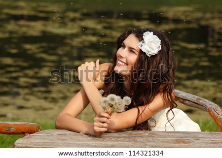 young woman with dandelions summer outdoor, beautiful bride has fun in summer park