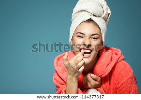 Cheerful attractive funny teen girl clean her teeth in the morning. Over blue background.