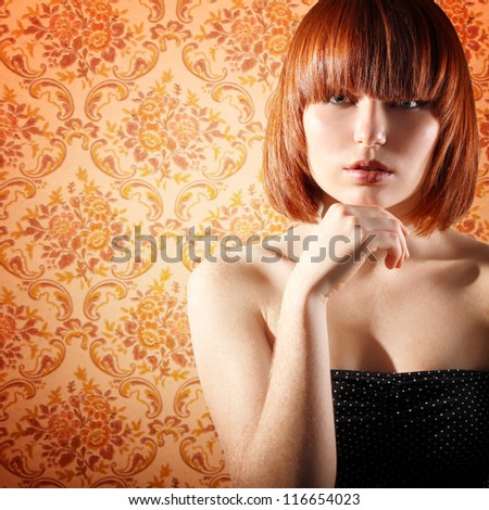 vintage portrait of young beautiful redheaded girl over retro wallpaper background