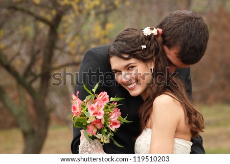wedding, young groom kiss bride in love over autumn nature background, park fall outdoor