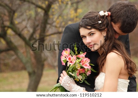 wedding, young groom kiss bride in love over autumn nature background, park fall outdoor