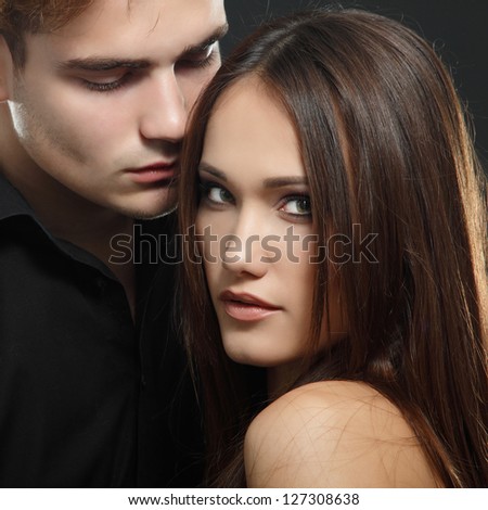 Sexy passion couple, beautiful young man and woman closeup, studio shot over black