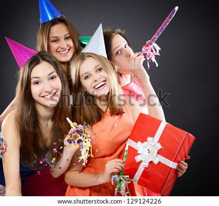 Joyful happy smiling teen girls have fun on birthday party, over black