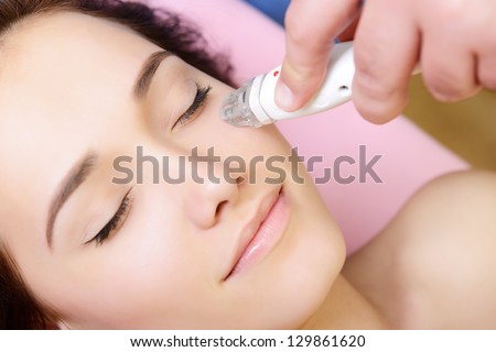 beautiful face of young woman and rejuvenated treatment, lady lies on a couch in a beauty spa getting electrostimulation lifting therapy