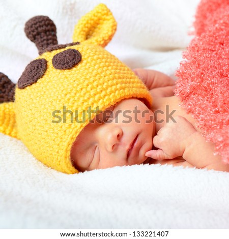 cute baby sleeping in funny hat and smiling in sweet dreams, beautiful kid\'s face closeup