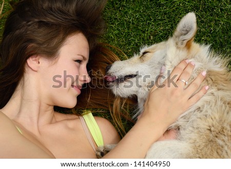 beautiful young happy laugh girl playing with her dog outdoor